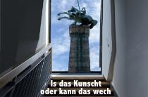 Ein Reiterdenkmal wächst aus dem Dachfenster